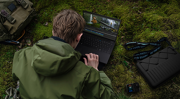 Hiker on mossy land using the PX13 laptop.