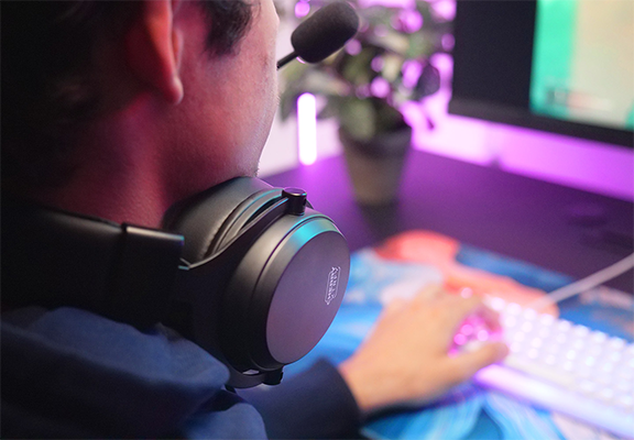 Gamer sat next to PC wearing H3 wireless headset so showcase its design