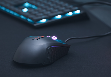 Mouse on a black mousemat as the focal point with blurred out keyboard in the background