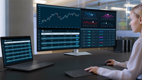 Image of a blonde haired woman using the monitor at a desk setup