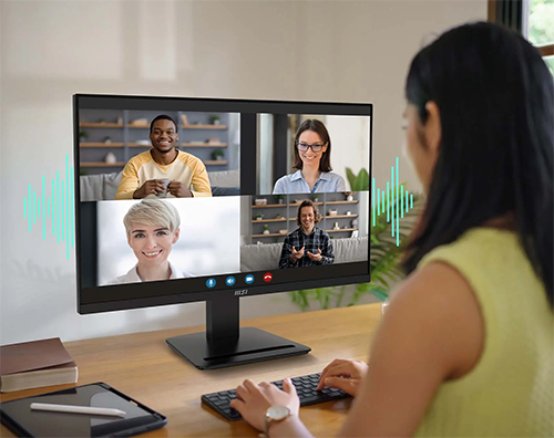 Lifestyle image of a woman on a group call using the monitor