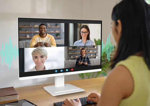 Lifestyle image of a woman on a group call using the monitor