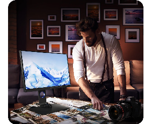 Image of a photographer reviewing prints on a desk with BenQ SW321C 4K Monitor