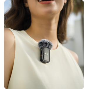 woman wearing black DJI MIc 2 on her collar of cream coloured vest top