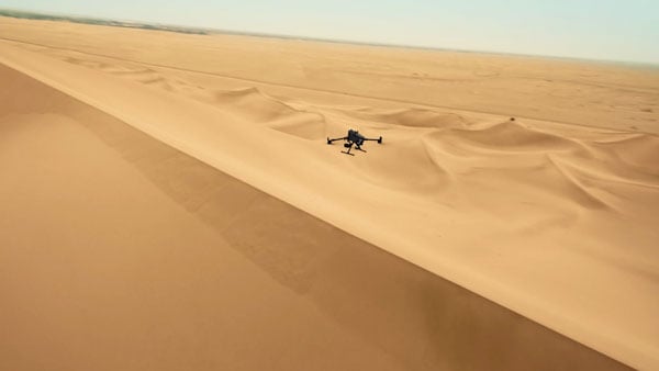 DJI Matrice 400 drone flying above desert sand dunes