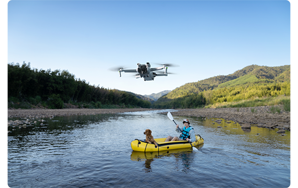 dji mini 3 over a lake with a man and a dog in a yellow boat