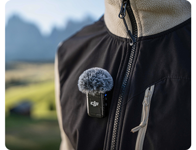 DJI Mic 2 clipped to a jacket being worn outside in a mountain location
