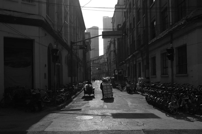 black and white sample image from fujifilm X-E5 of chinese street lined with bikes