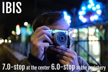 photographer using Fujifilm X-E5 on illuminated street at night
