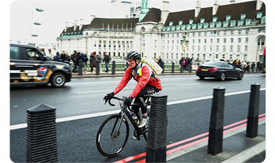 X100VI sample image of man riding bicycle along London bridge wearing red jacket