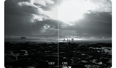 Fuji X100VI sample image comparison showing Film grain effect off and on black and white photograph of people walking along british beach