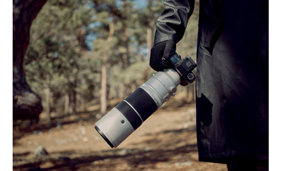 Fujifilm X-H2S being held by its handgrip with long telephoto lens attached