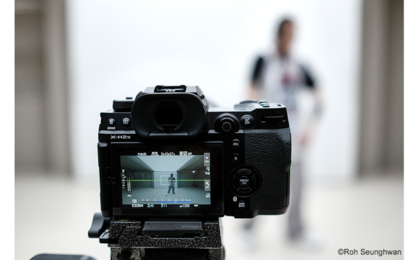 Fuji XH2S rear screen view of person stood infront of a white photography backdrop in a studio