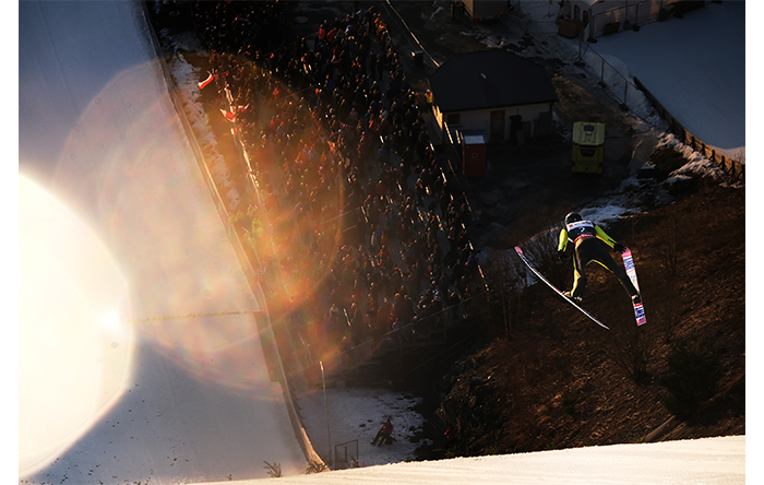 Fujifilm X-H2S Sample Image above shot of a skii jump competitor in flight with crowd in the background