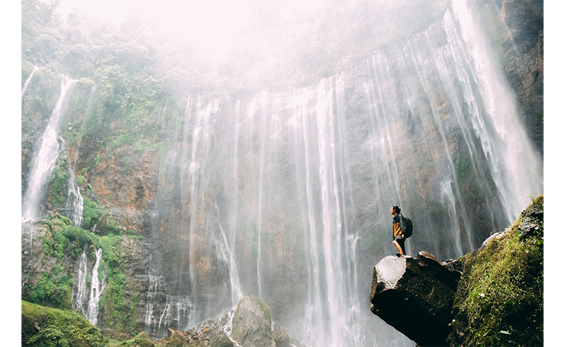 sample image of a man on a cliff face in front of a waterfall taken with the fujifilm xs20 using a 33mm lens
