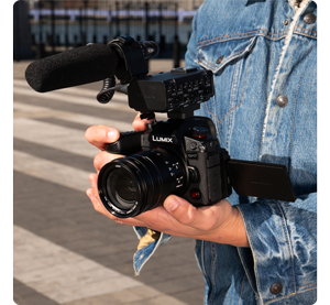videographer holding lumix GH7 with XLR microphone in hands