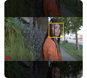 image of black woman standing against garden wall with plants with focus bracketing around faces