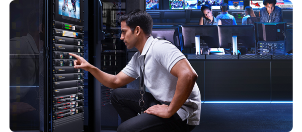 person pressing control buttons on blackmagic rackmounted video equipment