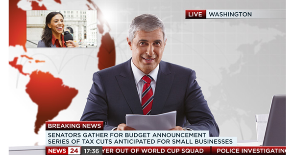 Image of male news presenter sat infront of red and white globe virtual newsroom set