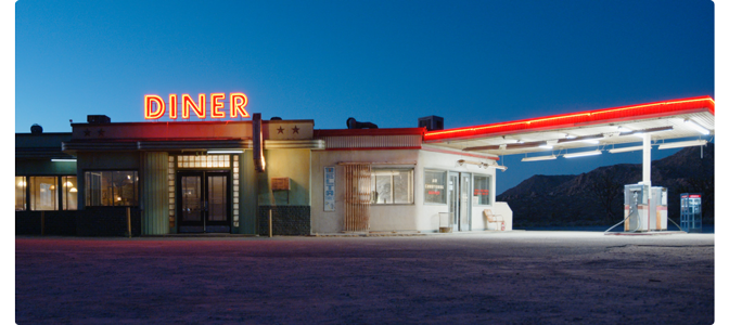 American west dessert Diner Gas Station with bright red neon lights and deep blue sky