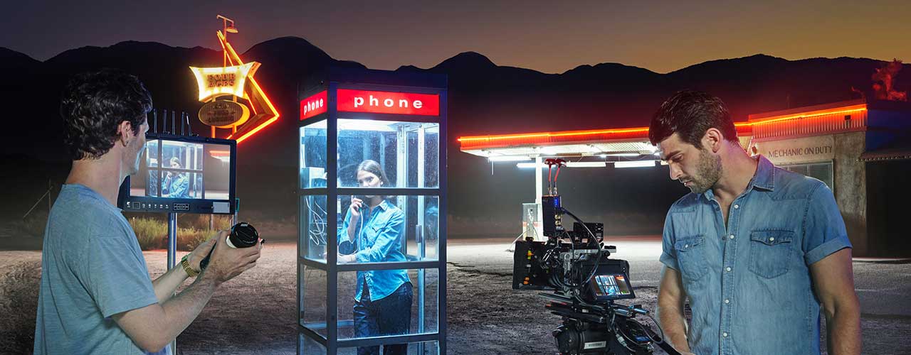 Video shoot of woman in a telephone booth at an american gas station with neon lights using Blackmagic Cinema Camera