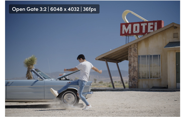 open gate 3:2 still of a man kicking dust in front of a car in a motel parking lot