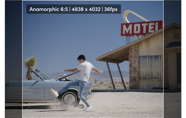 anamorphic 6:5 still of a man kicking dust in front of a car in a motel parking lot