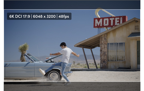 6K DCI 17:9 still of a man kicking dust in front of a car in a motel parking lot