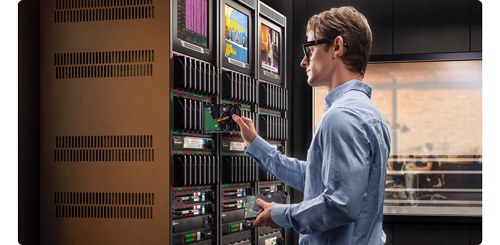 image of man inserting harddrives into Blackmagic Cloud Backup 8 rackmounted docks in production workflow