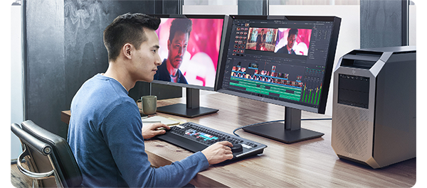 Video editor working on timeline in Blackmagic DaVinci Resolve Studio with two monitors on a wooden desk