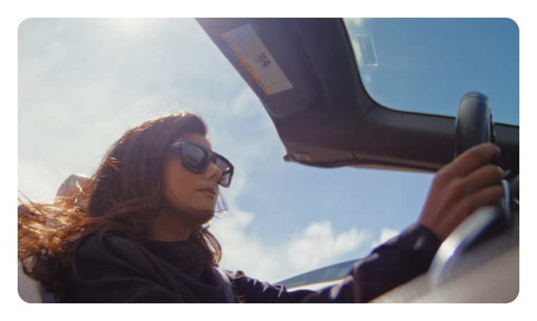sample blackmagic pyxis 12k hdr image of a woman in a car with sun glasses on