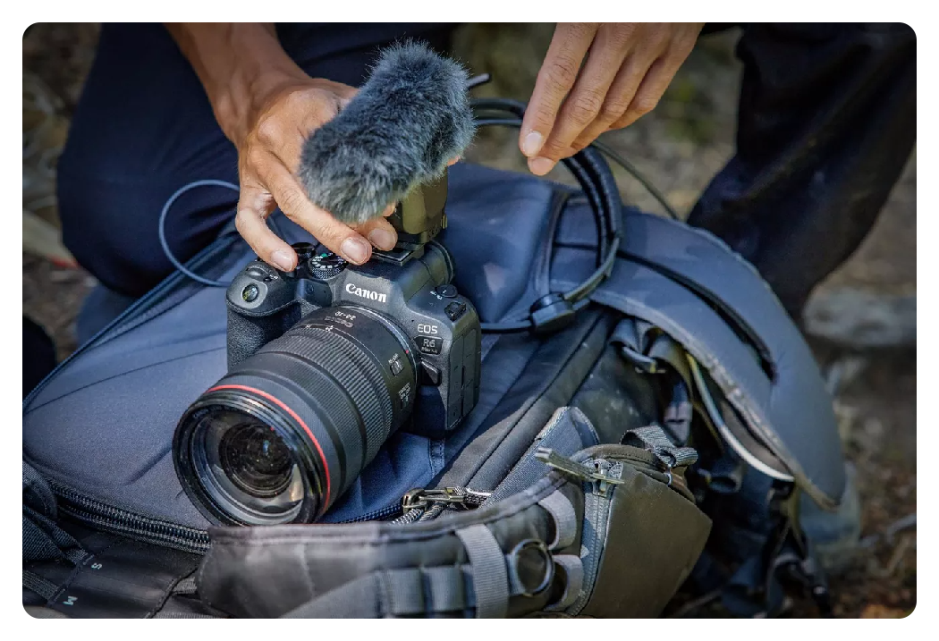 canon r6 mark ii on top of a backpack with a mic attached with wind shield