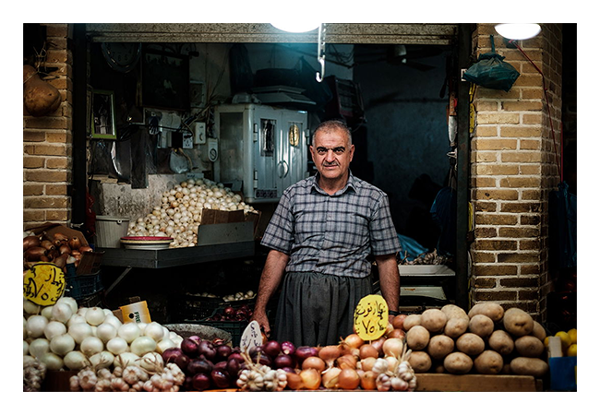 sample image of a man in front of a fruit stall taken with the fujifilm 35mm 1.4 lens