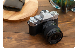 Fujifilm X-T50 silver camera and with 15-45mm lens on wooden table