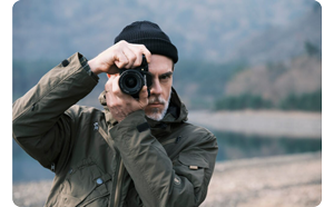 photographer holding Fujifilm X-T50 up to right eye capturing photographs looking directly at