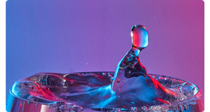 Image of water droplets lit with blue red and purple LED lighting