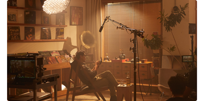 image of man reclining in a chair surrounded by vinyl record storage and Godox Lighting equipment