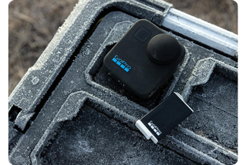 GoPro MAX 360 action camera and battery sitting on frozen plastic case