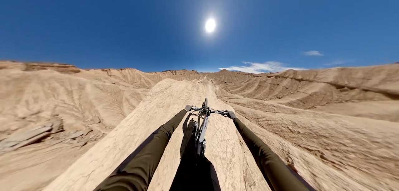 Ultra wide FOV image of mountain bike rider travelling along desert ridge