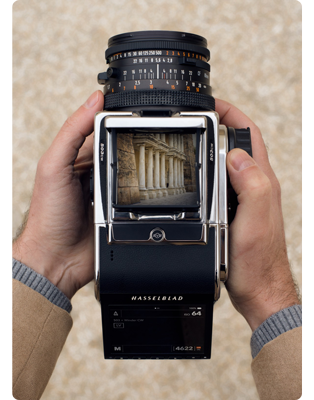 photographer holding Hasselblad 503CW with CFV 100C digital back looking through the viewfinder at the columns of Petra