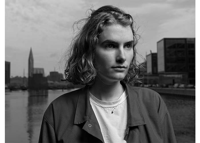 Hasselblad X2D 100C Lightweight Field Kit Sample Image black and white portrait of a woman with shoulder length hair infron of a cityscape
