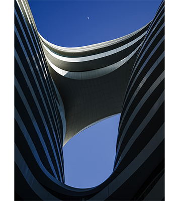 Hasselblad XCD35-75mm F3.5-4.5 Zoom Lens Sample Image of modern flowing architecture building with silver and black layers against a clear blue sky