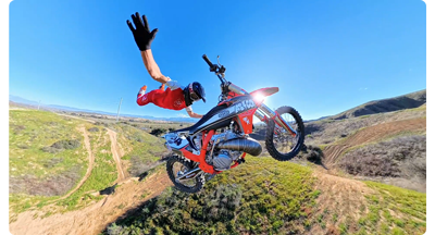 motocross rider jumping orange bike across sky