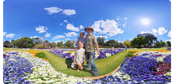 family standing in sunny and vibrant flower gardens