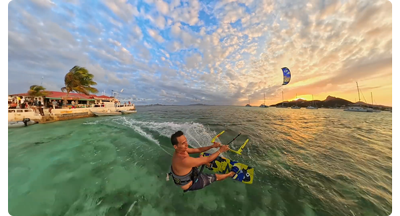 kiteboarder riding waves at sunset