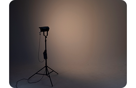 Nanlite FC-300B in a photography studio illuminating a wall with warm orange yellow light