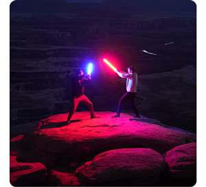 two men standing on rock dueling with Nanlite PavoTube Light tubes in red and blue