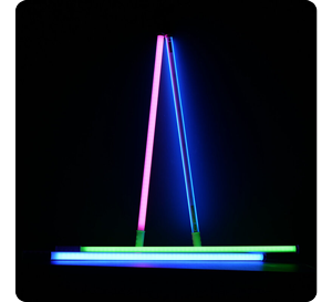 4 PavoTube T8-7X LED Light Tubes illuminated in RGB on a black background