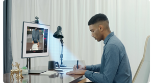 Person working at desk with computer screen and OBSBOT Tiny2