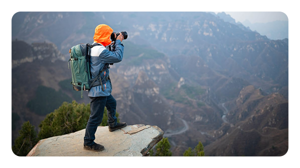 somone taking a photo stood at the top of a mountain range